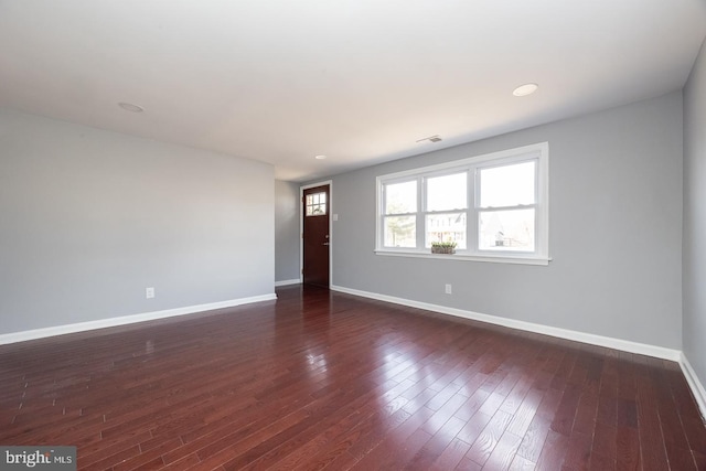 unfurnished room with visible vents, baseboards, dark wood-style flooring, and recessed lighting