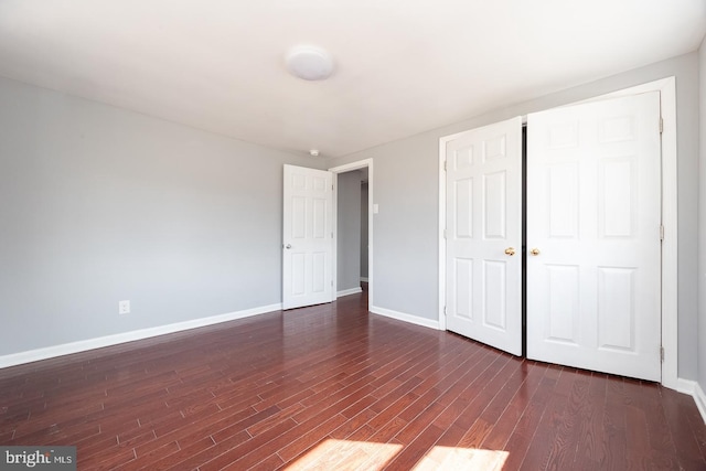 unfurnished bedroom featuring dark wood finished floors and baseboards