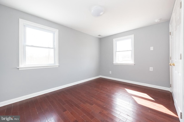 unfurnished room with hardwood / wood-style floors and baseboards