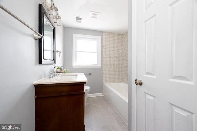 bathroom featuring baseboards, visible vents, vanity, and toilet