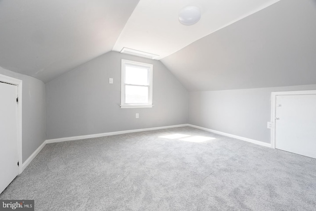 bonus room with lofted ceiling, carpet flooring, and baseboards