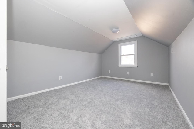 additional living space featuring lofted ceiling, carpet, and baseboards