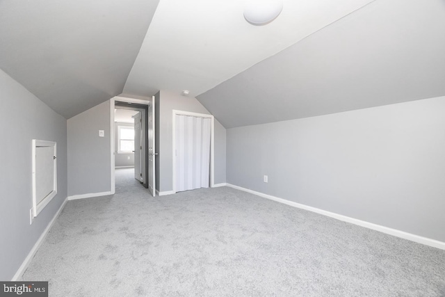 bonus room with carpet floors, baseboards, and vaulted ceiling