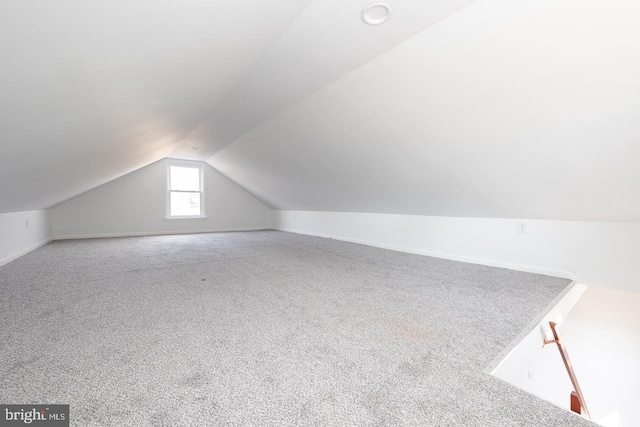 additional living space featuring lofted ceiling and carpet floors