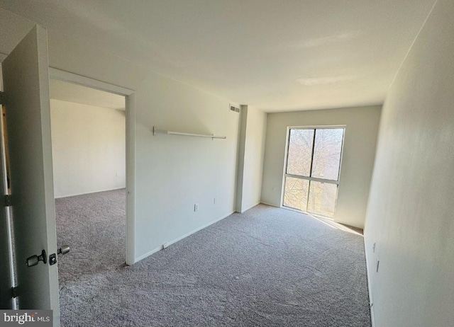 empty room with visible vents and carpet flooring