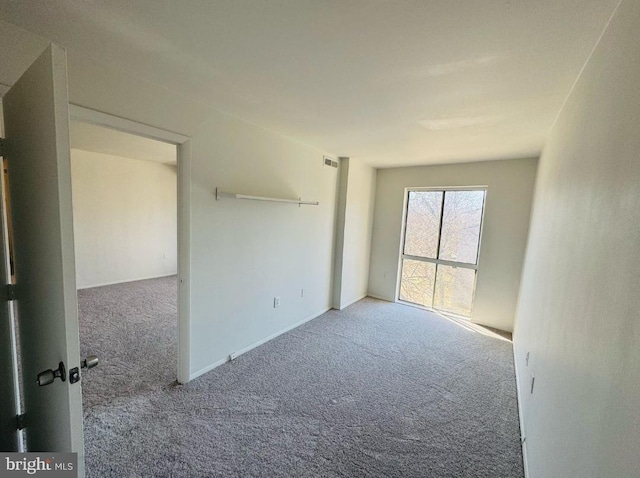 unfurnished room with carpet floors and visible vents