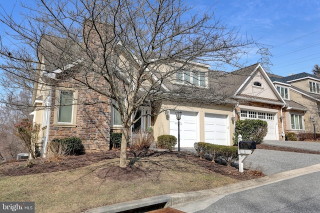 view of front of house with stucco siding, driveway, stone siding, roof with shingles, and an attached garage