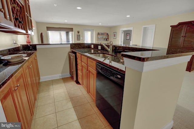 kitchen with dark stone countertops, light tile patterned floors, recessed lighting, a sink, and dishwasher