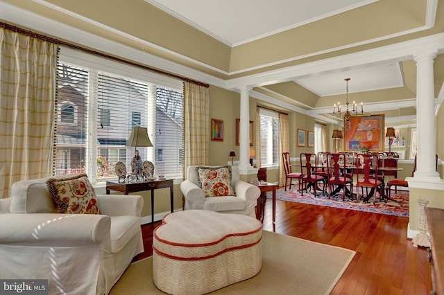 sitting room featuring hardwood / wood-style floors, ornate columns, and ornamental molding