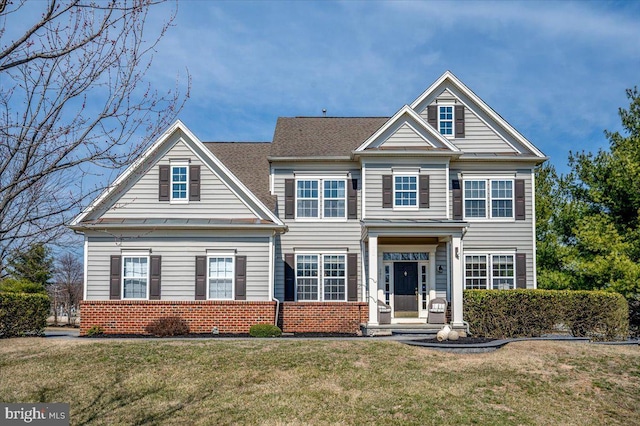 view of front facade featuring brick siding, a front lawn, and roof with shingles