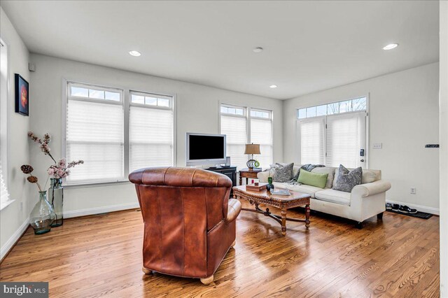 living area featuring recessed lighting, baseboards, and wood finished floors