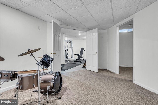 exercise room featuring carpet, baseboards, and a drop ceiling