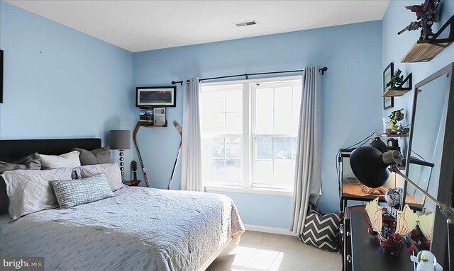 bedroom with light carpet, visible vents, and baseboards