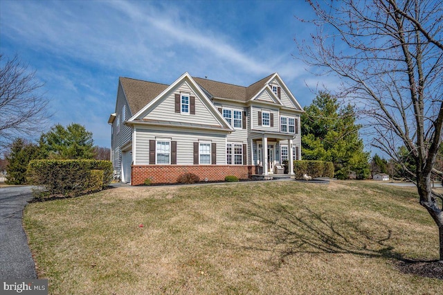 view of front of house featuring a front lawn, a garage, brick siding, and aphalt driveway