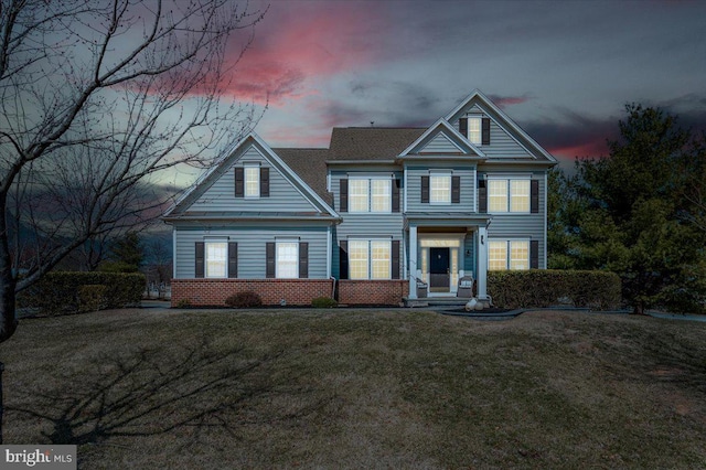 view of front facade featuring brick siding and a front yard