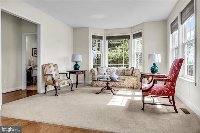 sitting room with wood finished floors, carpet flooring, baseboards, and visible vents