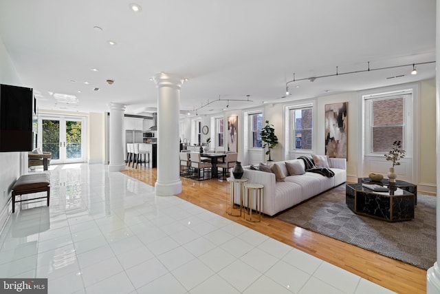 tiled living room with decorative columns, track lighting, and recessed lighting