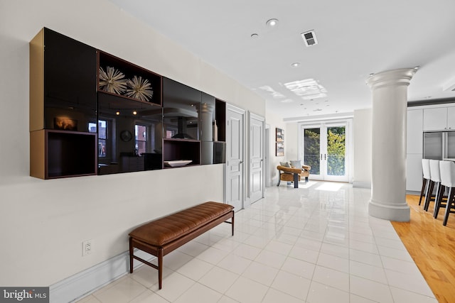 hall with visible vents, french doors, tile patterned flooring, and decorative columns