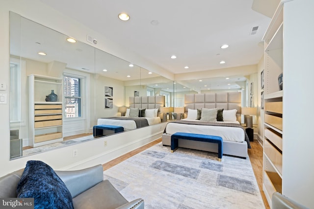 bedroom with wood finished floors, visible vents, and recessed lighting