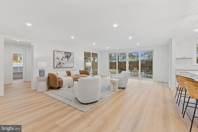 living area featuring recessed lighting, light wood-style flooring, and baseboards