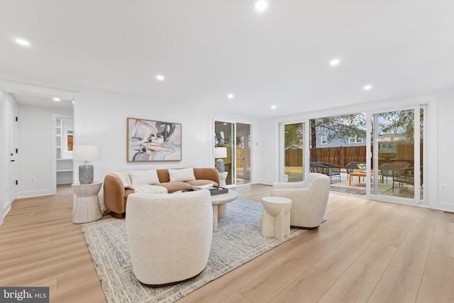 living room featuring light wood-type flooring, baseboards, and recessed lighting