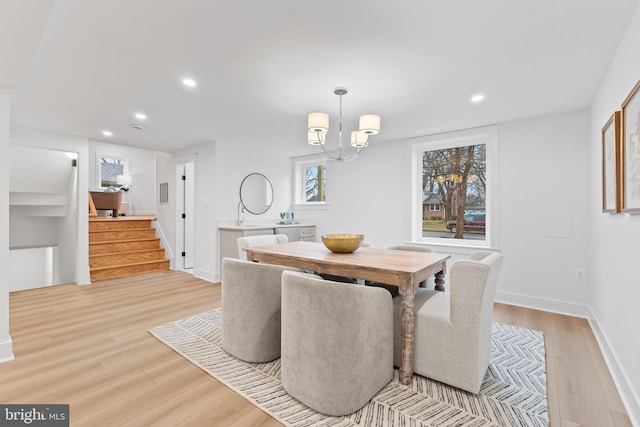 dining space featuring light wood finished floors, baseboards, stairs, a notable chandelier, and recessed lighting