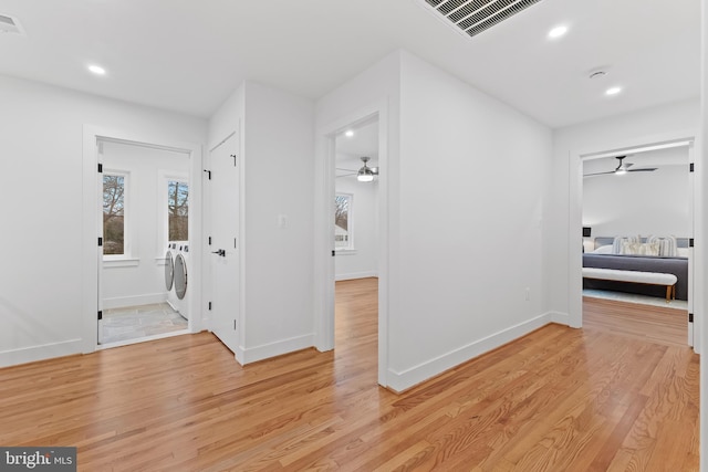 hall with baseboards, washer and clothes dryer, light wood-style flooring, and recessed lighting