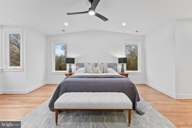 bedroom with light wood-type flooring, multiple windows, and vaulted ceiling