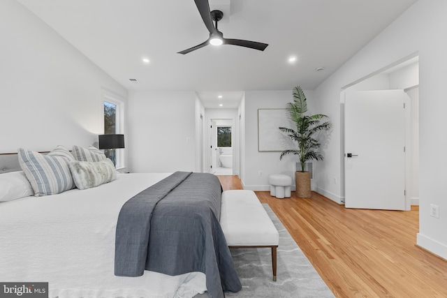 bedroom featuring baseboards, multiple windows, and light wood-style floors