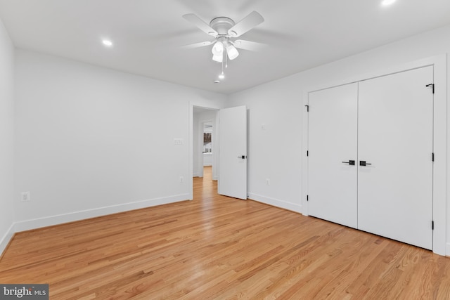 unfurnished bedroom with light wood-style flooring, baseboards, ceiling fan, and a closet