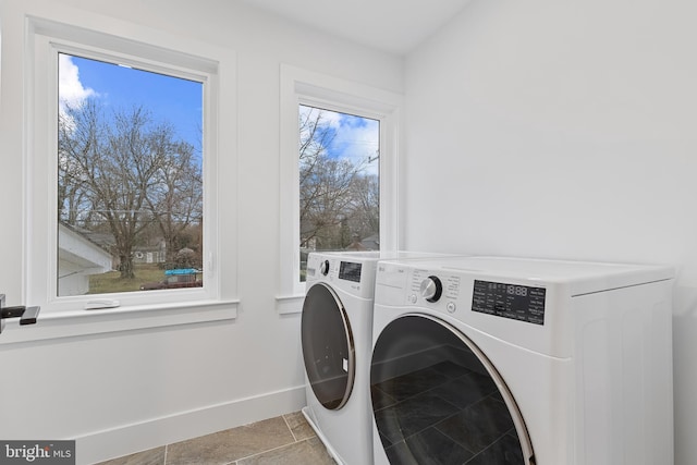 washroom with tile patterned flooring, laundry area, independent washer and dryer, and baseboards