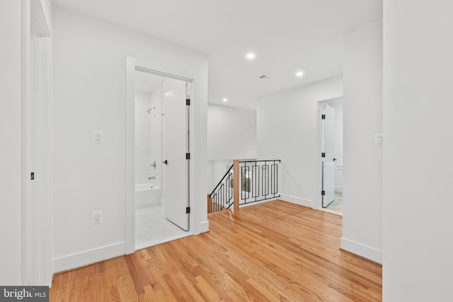 spare room featuring light wood-style floors, recessed lighting, visible vents, and baseboards