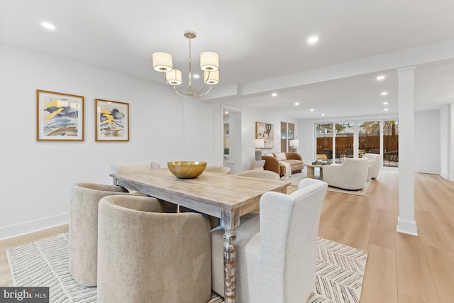 dining space with light wood-style flooring, baseboards, a notable chandelier, and recessed lighting