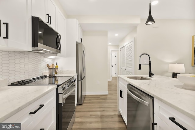 kitchen featuring stainless steel appliances, a sink, and white cabinetry