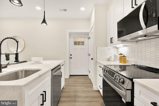 kitchen with electric stove, decorative backsplash, white cabinets, a sink, and dishwasher