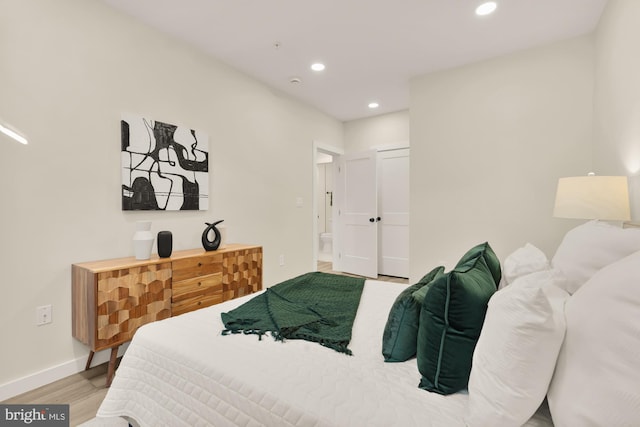 bedroom featuring baseboards, wood finished floors, and recessed lighting