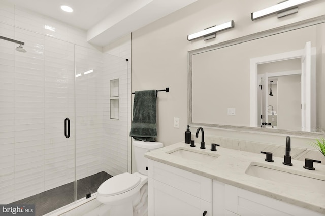 full bathroom with toilet, a stall shower, double vanity, and a sink