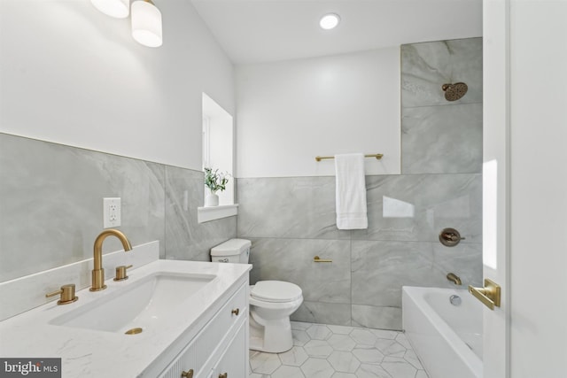 full bathroom with toilet, a bath, walk in shower, vanity, and tile walls