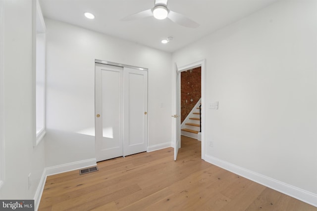 spare room with a ceiling fan, baseboards, visible vents, and light wood finished floors