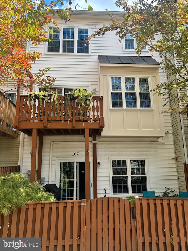 view of front of house with a standing seam roof and a fenced front yard