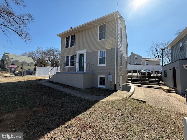 rear view of house featuring fence