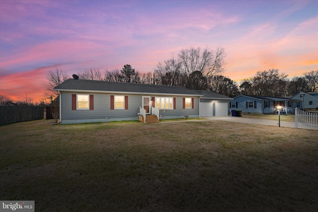 single story home featuring a yard, concrete driveway, fence, and an attached garage