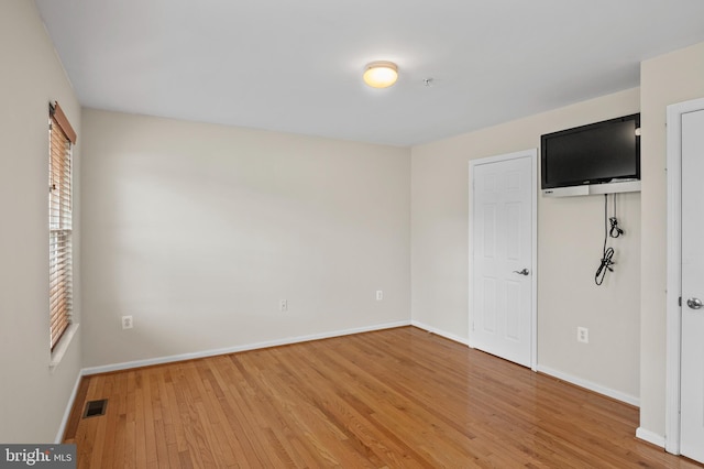 unfurnished bedroom featuring light wood finished floors, visible vents, and baseboards