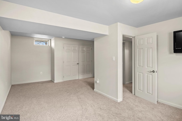 unfurnished bedroom featuring carpet, a closet, and baseboards