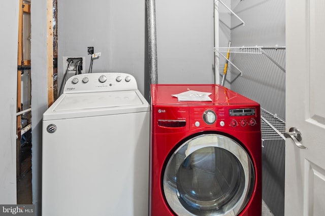 clothes washing area featuring laundry area and washer and clothes dryer