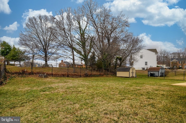 view of yard with a fenced backyard, an outdoor structure, and a shed