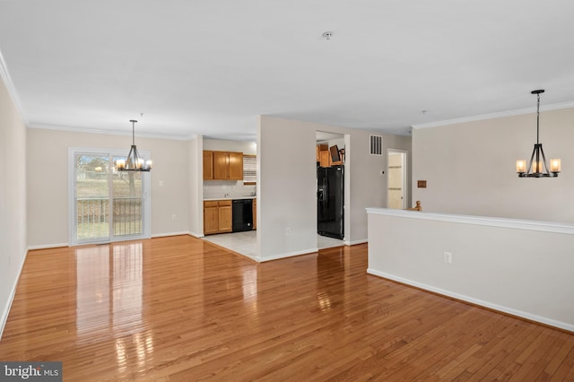 unfurnished living room with crown molding, visible vents, a notable chandelier, and light wood finished floors