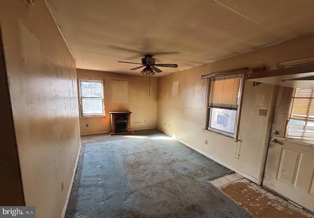 unfurnished living room with ceiling fan