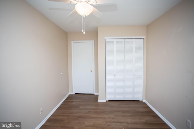 unfurnished bedroom featuring ceiling fan, a closet, dark wood finished floors, and baseboards