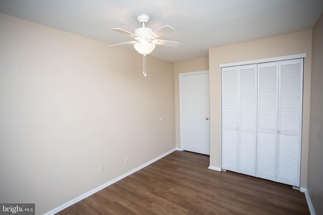 unfurnished bedroom featuring a ceiling fan, a closet, baseboards, and wood finished floors